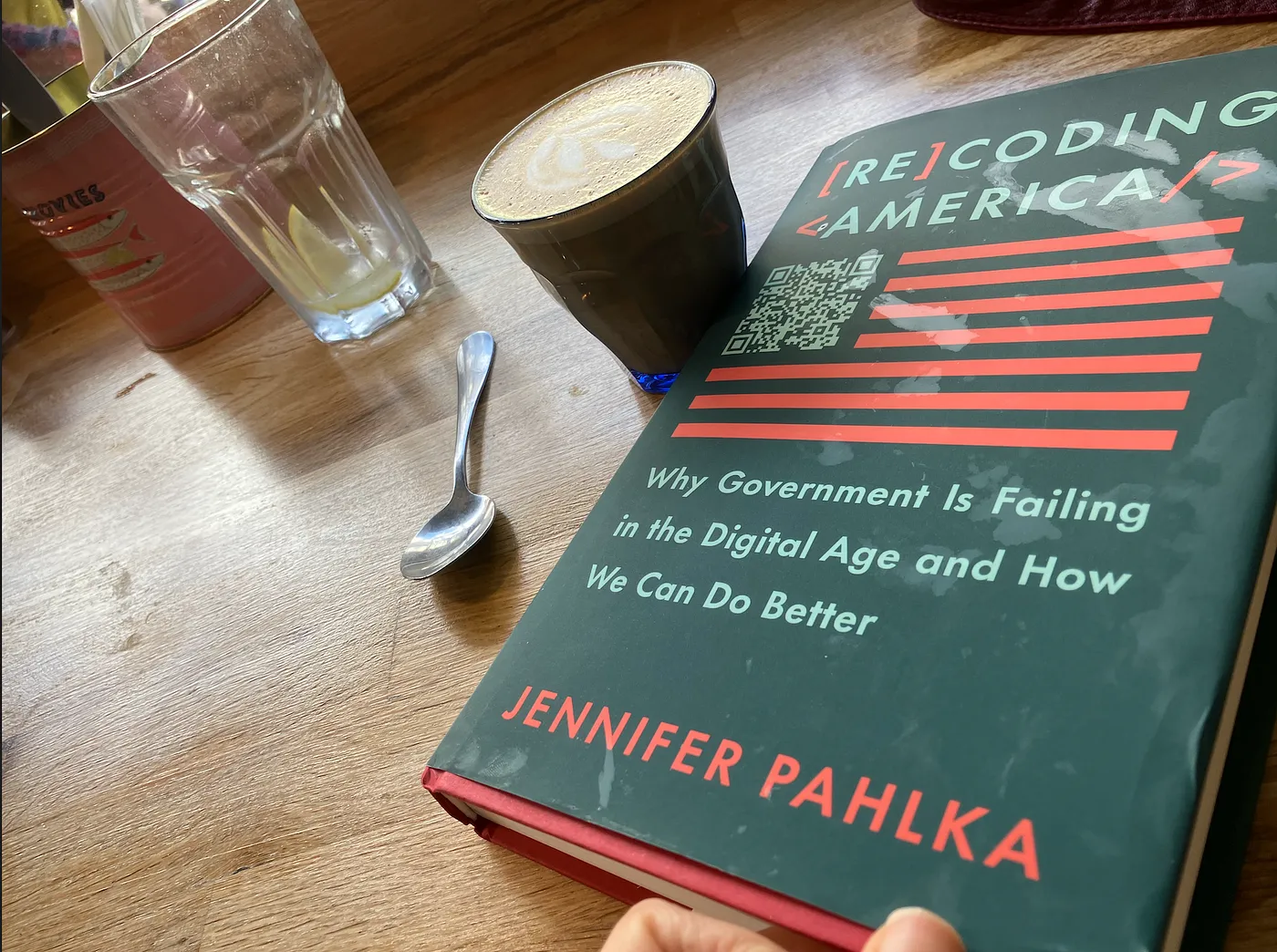 "Recoding America - Why government is failing in the digital age and how we can do better" book with coffee