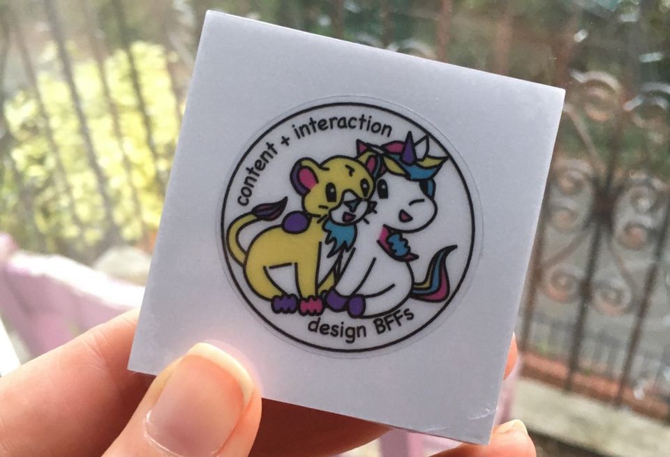 A sticker of a cartoon unicorn and lion, with the sticker "content and interaction - design BFFs"